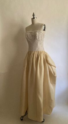 1980s gorgeous Carolina Herrera form fitting beaded gown with cream silk skirt. Strapless bodice has boning  and is lined in white silk; zips up the back with a hook and eye to finish the closure. Silk skirt is gathered at the hip for volume and skirt is fully lined in white silk. Dress is in very good vintage condition. There is one small light gray spot in the back of the dress about an inch long. Dress has been cleaned. Chest 34-36" Waist 28" Hips-open Length from top of chest to hem  52" Vin Spring Evening Boned Bodice, Elegant Spring Evening Bodice, Silk Wedding Corset Dress With Lined Bodice, Strapless Beige Corset Dress For Evening, Beige Strapless Corset Dress For Evening, Elegant Cream Corset Evening Dress, Fitted Cream Ball Gown Evening Dress, Fitted Summer Evening Dress For Debutante Ball, Cream Fitted Bodice Evening Dress For Gala