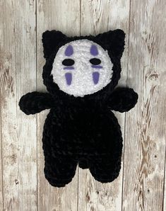 a black and white teddy bear with purple eyes