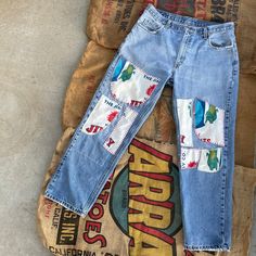 an old pair of jeans with patches on them sitting on top of a pile of bags