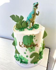 a birthday cake with a dinosaur on top