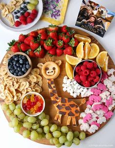 a wooden platter filled with fruit and snacks