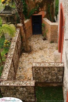 an outdoor area with stone walls and steps leading to a blue door in the center