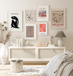 a bedroom with white walls and pictures on the wall