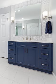 a bathroom with blue cabinets and white tile