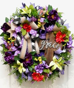 a wreath with the word grace written on it and purple flowers in front of it