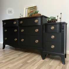 a black dresser with lots of drawers and knobs on it's sideboard