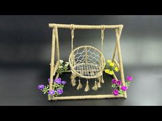 a macrame frame with flowers and a birdcage hanging from the side