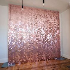 a room with wooden floors and a wall made out of pink mosaic tiles on the wall