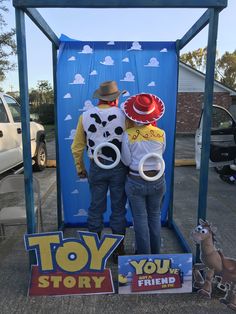 two people standing in front of a toy story booth