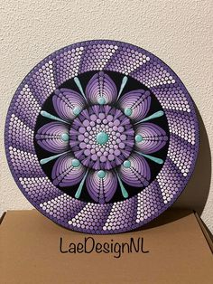 a purple and black plate sitting on top of a cardboard box