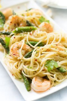 pasta with shrimp and asparagus on a white plate