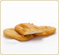 two pieces of fried food sitting next to each other on a white surface with a gold frame around it