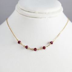 This dainty handmade necklace features 5 genuine Ruby gemstones wrapped on a chain. This delicate choker necklace is beautiful worn alone or layered with other necklaces. A classic and simple everyday piece that will make fashion look effortless. Customize yours by choosing your metal and length. This necklace design is also available in different gemstones. Makes a great gift to add to any gemstone lover's collection. Perfect to gift for Christmas, Valentine's Day, Mother's Day, and more! Gemst Dainty Wire Wrapped Necklaces With Round Beads, Dainty Wire Wrapped Round Bead Necklaces, Dainty Wire-wrapped Necklaces With Round Beads, Dainty Ruby Necklaces, Elegant Ruby Beaded Necklace Gift, Dainty Ruby Gemstone Birthstone Necklace, Dainty Ruby Gemstone Necklace, Red Ruby Gemstone Beaded Necklaces, Delicate Choker Necklace