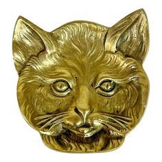 a close up of a cat head on a white background with a gold colored finish