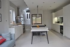 an open kitchen and dining room with white walls