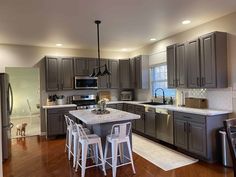 a kitchen with wooden floors and gray cabinets