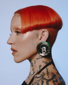 a woman with red hair and piercings on her neck