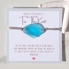 there is a card with a blue bead on it that says thank you for helping us tie the knot