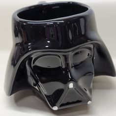 a black coffee cup with a darth vader face on it