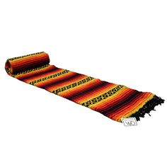 an orange, yellow and black striped rug with fringes on the bottom is shown