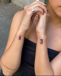 two women with matching tattoos on their arms