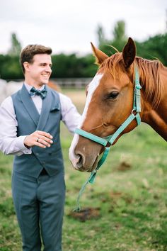 a man standing next to a brown horse in a field