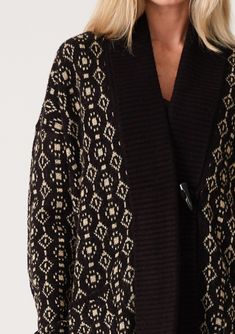 An ultra-warm mid-length cardigan in a black and taupe geo jacquard design. Geo jacquard Relaxed fit Long sleeve Drop shoulder Mid-length Shawl collar Toggle button closure Side pockets Contrast ribbed trim Bohemian cardigan An effortless slouchy cardigan designed in a cool geo jacquard pattern. Featuring a warm shawl collar, essential side pockets, and long sleeves with a relaxed dropped shoulder. The toggle closure secures at the front. Model is 5'9, wearing a size S/M. Style: I-50249K-SMG Black Jacquard Knit Cardigan For Fall, Fall Jacquard Knit Cardigan For Layering, Black Jacquard Knit Outerwear For Fall, Beige Jacquard Knit Long Sleeve Outerwear, Black Jacquard Knit Long Sleeve Outerwear, Elegant Jacquard Knit Winter Outerwear, Elegant Jacquard Knit Outerwear For Winter, Elegant Jacquard Knit Cardigan For Winter, Fall Cardigan For Cold Weather With Jacquard Knit