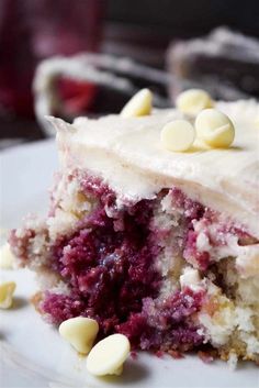 a close up of a piece of cake on a plate with white frosting and chocolate chips