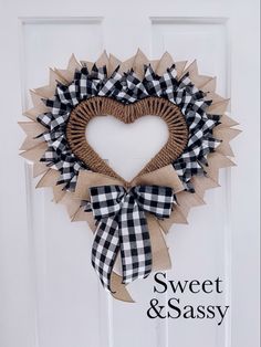 a heart shaped wreath hanging on a door with the words sweet and sassy written below it