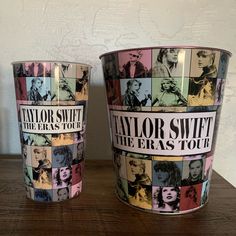 two buckets with taylor swift and the eras tour stickers on them sitting on a table