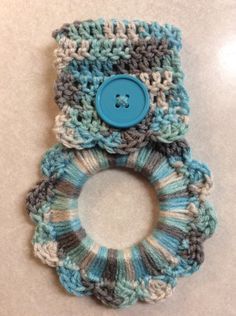 two crocheted hair ties with a blue button on top of each one in the shape of a flower