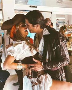 a man and woman dressed up as pirates kissing