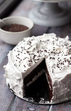 a cake with white frosting and chocolate sprinkles