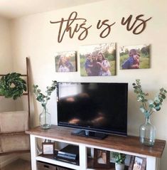 a flat screen tv sitting on top of a white entertainment center next to a wooden shelf