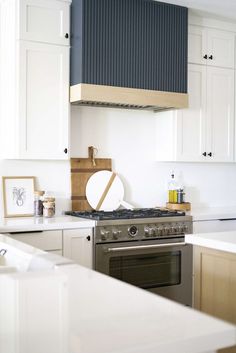 a stove top oven sitting inside of a kitchen next to white cabinets and counter tops