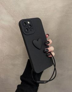 a woman's hand holding up a black phone case with a heart on it