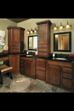 a bathroom with wooden cabinets and black counter tops, along with a stool in front of the sink