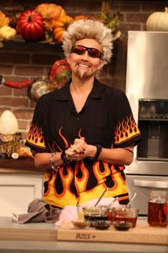 a woman with blonde hair standing in front of a stove