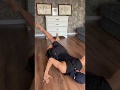 a man laying on the floor in front of a dresser with his legs spread out