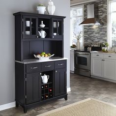 a kitchen area with a black cabinet and white vases