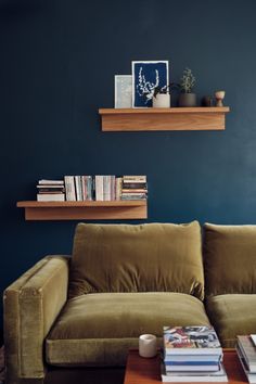 a living room filled with furniture and a book shelf on the wall next to a coffee table