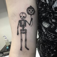 a skeleton with a balloon tattoo on the arm