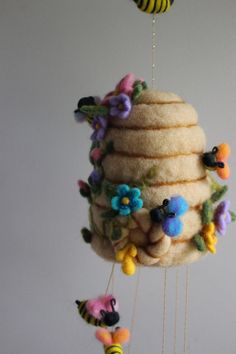 a mobile made out of felt with bees and flowers hanging from it