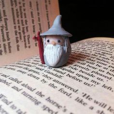 a small figurine sitting on top of an open book