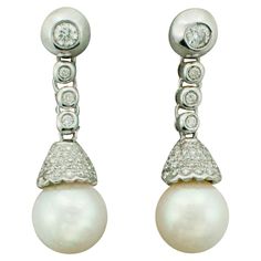 Pearl and Diamond Earrings in 18k Two 9 mm Cultured Pearls Ninety Six Round Brilliant Cut Diamonds weighing .80 carats approximately [bright with no imperfections visible to the naked eye] GH SI Elegant Pave Setting Diamond Earrings For Formal Occasions, Elegant Formal Diamond Earrings With Pave Setting, Luxury Platinum Pearl Earrings For Formal Occasions, Formal Diamond Pearl Earrings With Brilliant Cut, Formal Brilliant Cut Diamond Pearl Earrings, Elegant Platinum Diamond Earrings, Luxury Pearl Earrings With Pave Setting For Formal Occasions, Formal Fine Jewelry Pearl Earrings With Pave Setting, Elegant Platinum Pearl Earrings For Formal Occasions