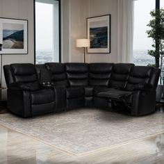 a living room with a large black sectional couch and reclining chair in front of a window