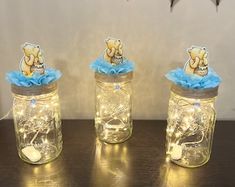 three jars with teddy bears in them on a table