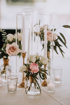 flowers in vases and candles on a table