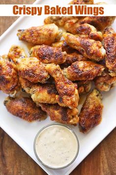 crispy baked wings on a white plate with ranch dressing in the background and text overlay that reads crispy baked wings