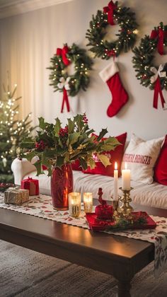 a living room decorated for christmas with wreaths on the wall and candles in vases